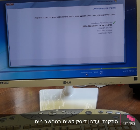 מסך מחשב עם הודעת עדכון חלונות ומקלדת ישנה